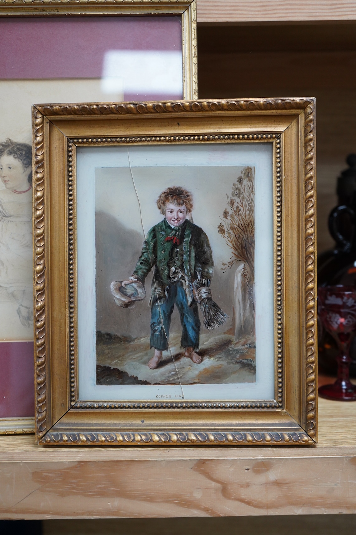 English School (19th century), Young girl seated playing with a doll, signed initials and dated 1834, pencil drawing heightened in red, together with a small oil on copper, study of a young beggar, inscribed 'Copper your